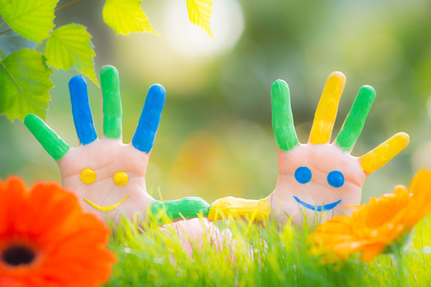 a photo of two children's hands painted with smiley faces